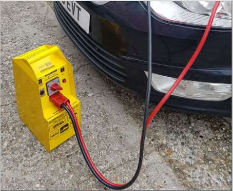 Recovery technician assisting a car with hazard lights on