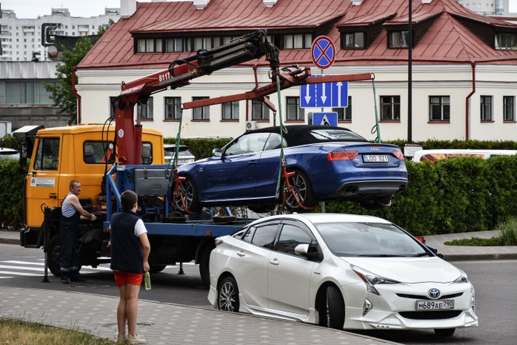 Tow truck transporting a car to a local authority vehicle pound