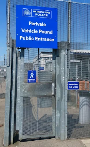 Recovery driver securing a car onto a recovery truck outside a vehicle pound